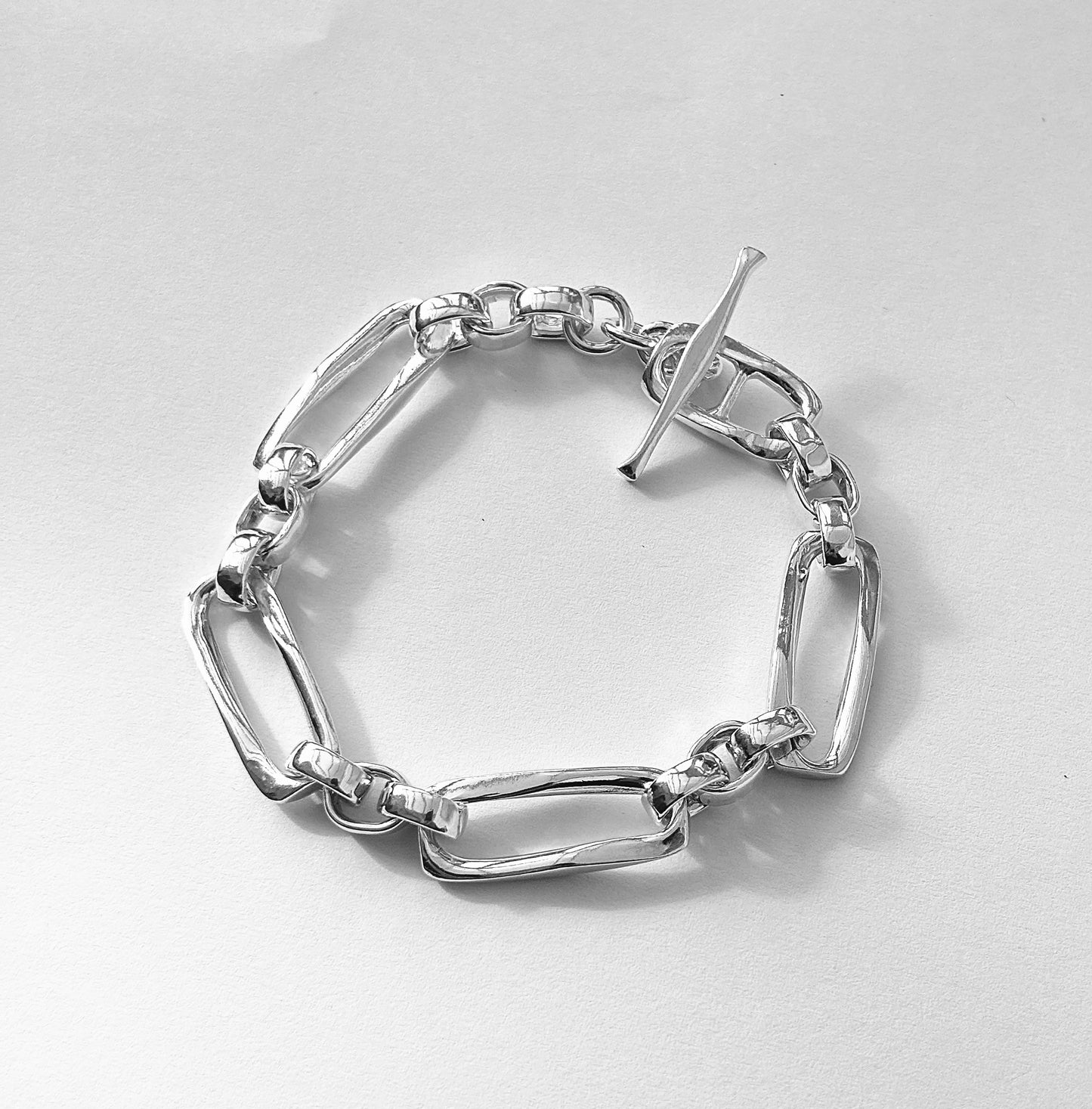 Long links, joined with smaller belcher links, create this beautiful hand made chain bracelet, with T bar clasp. Sterling silver