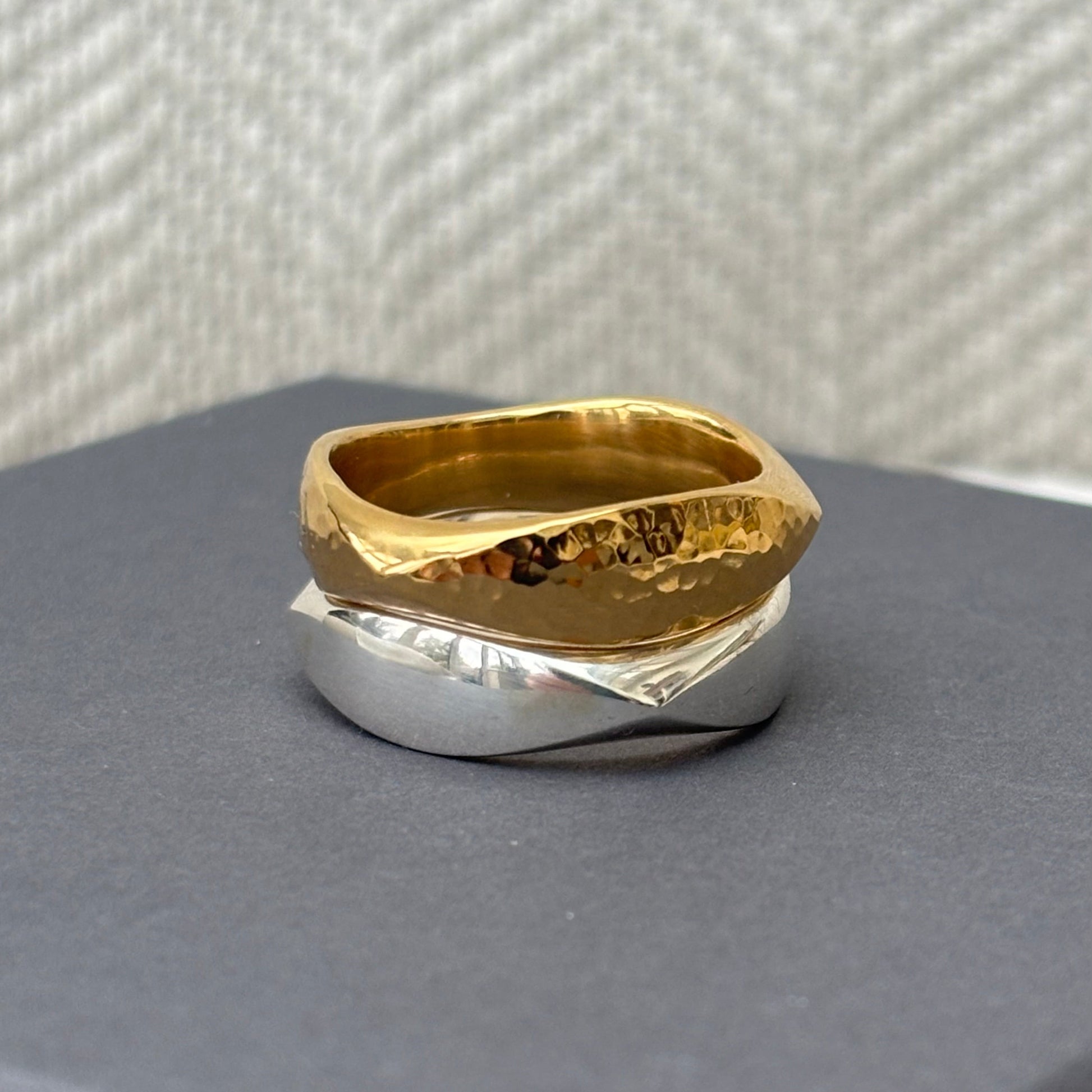 Gold and silver ring on a textured surface
